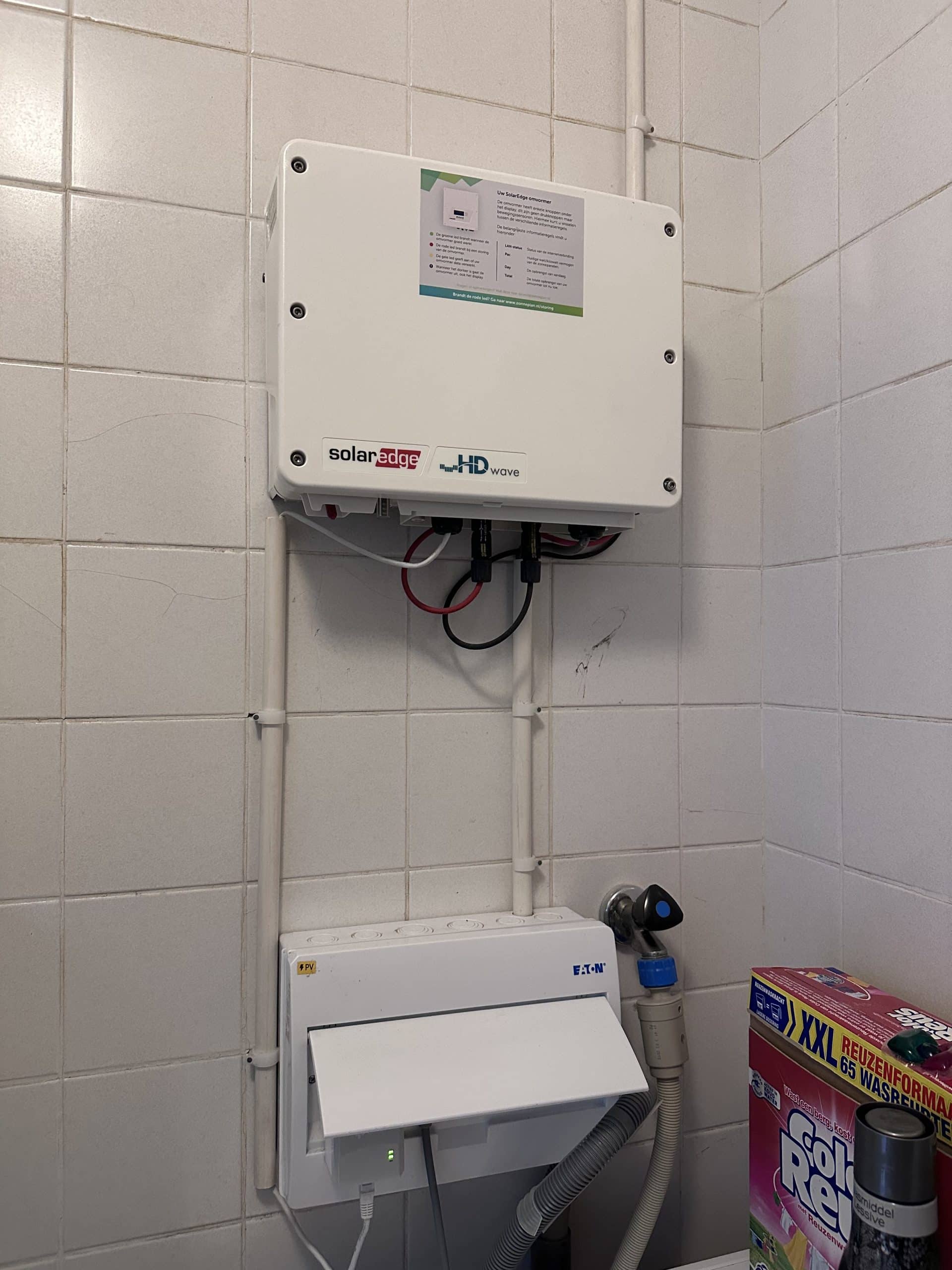 Oude omvormer van een zonnepaneleninstallatie aan de muur, voor vervanging